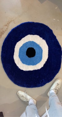 a blue and white rug with an evil eye on it