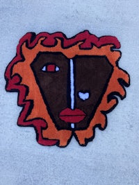 a black and orange rug with a face on it