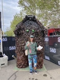 a person standing in front of a giant stuffed animal